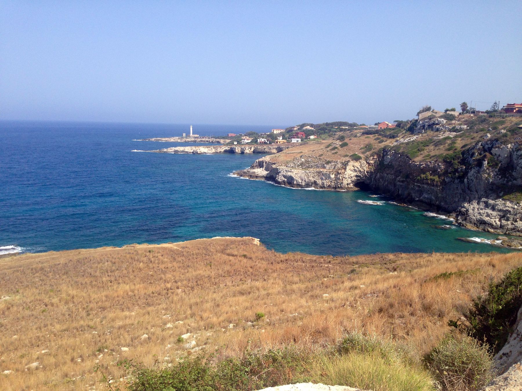 La baia a nord di Capo Santa Croce, con il faro sulla punta in lontananza