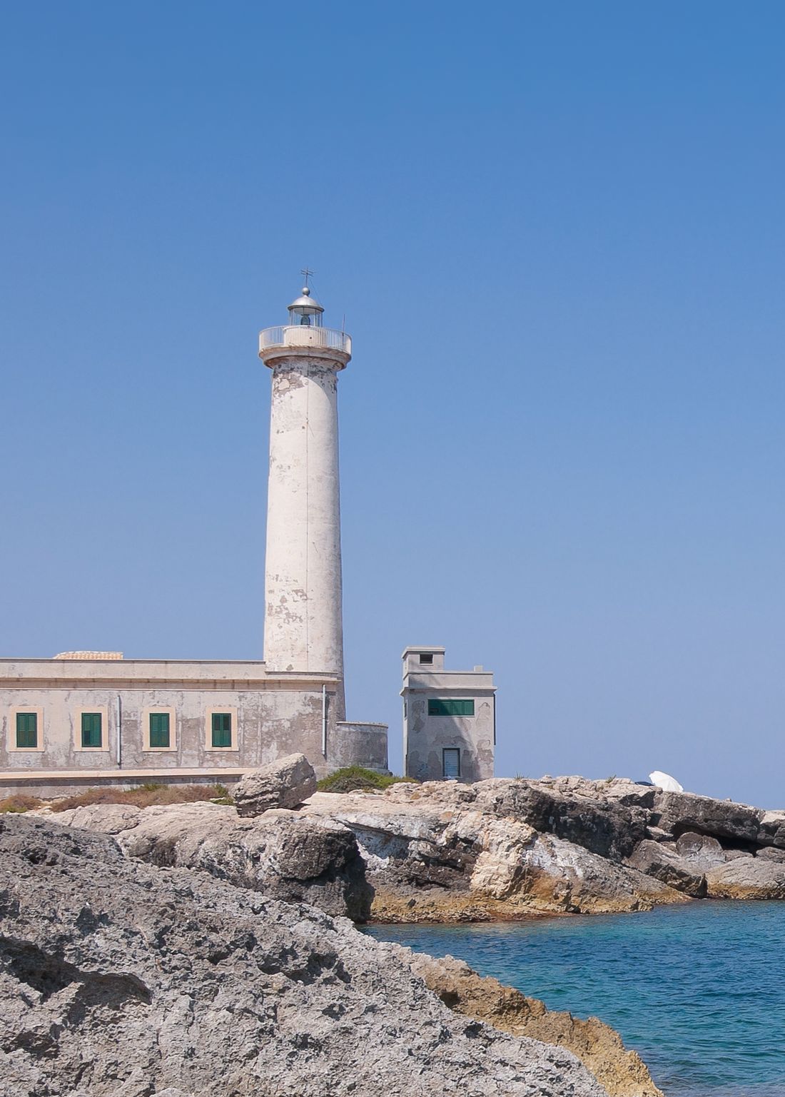 La torre del faro di Capo Santa Croce contro il cielo, sopra la casa del guardiano